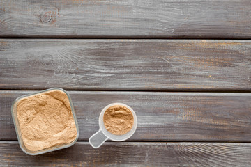 Nutrition for workout with protein cocktail powder on wooden background top view mockup