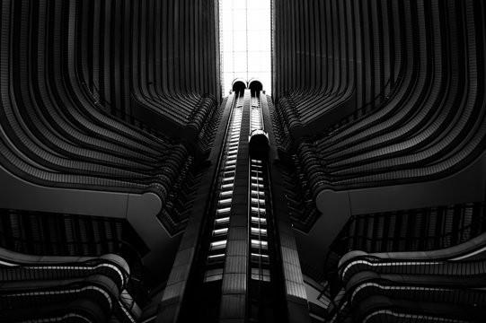 Black-and-white shot of the inside of a skyscraper with its elevators in the center