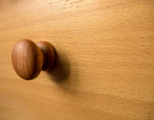Wooden brown knob on a wooden background