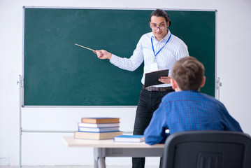 Young male teacher and boy in the classroom