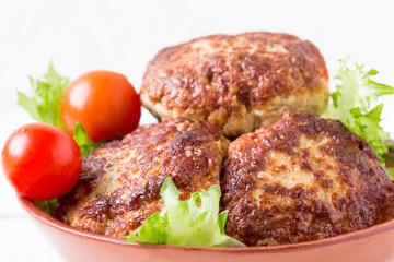 Homemade meatballs with tomatoes and salad in a bowl.