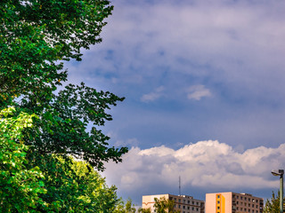 Massive clouds above the houses in the distance on the blue sky