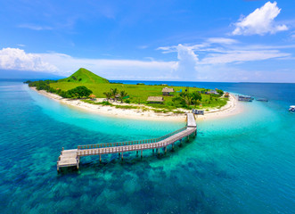 Top view of small isolated tropical island with white sandy beach and blue transparent water. Kenawa Island