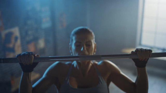 Beautiful Strong Woman Doing Pull-Ups in the Hardcore Gym. Gorgeous Professional Female Athlete Does Chin-up Power, Strength and Cross Fitness Exercises and Everyday Workout Routine. Elevated Shot
