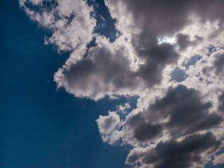 The sun behind the clouds on a blue sky