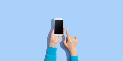 Person using a white smartphone - overhead view
