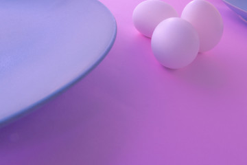 A light blue neutral plate with white chicken eggs on a neutral pink background. Free space to write.
