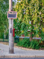 Road mirror on the pillar at the edge of the road