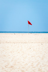 Red flag warning danger on a beach
