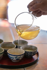 woman 's hand is brew tea with a cup of tea.