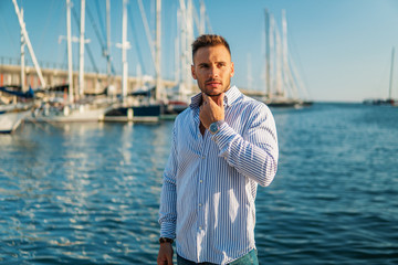 Young rich man at Yacht Club. Businessman is Relaxing in the gulf with seaview and luxury ships