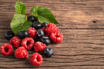 Fresh mixing for blueberry and raspberries on wooden background.