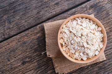 Oat flakes in wooden bowl on wooden table. Oatmeal, Oats - Food, Oat Flake.