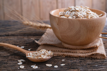Oat flakes in wooden bowl and spoon on wooden table. Oatmeal, Oats - Food, Oat Flake.