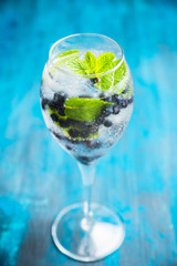 Billberry mojito cocktail in wine glass. Selective focus. Shallow depth of field.