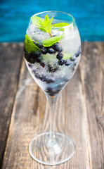 Billberry mojito cocktail in wine glass. Selective focus. Shallow depth of field.