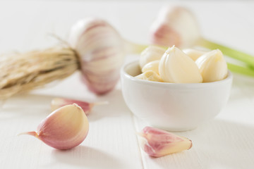 Fresh garlic and parsley scattered on a white table. Component of traditional medicine.
