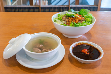 Delicious pork noodle soup and herbs in Asian restaurant