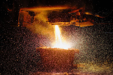 A stream of hot metal pours into the ladle. Electric arc furnace shop EAF. Metallurgy.