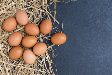 Fresh eggs from the farmer's farm have eggs and rice straw on a black background table.