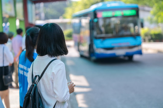 Young girl waiting for bus at bus station. Closeup.