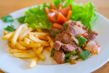 Close up photo of delicious stir-fried beef and french fries