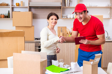 Young male contractor and female customer in moving concept