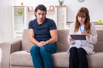 Young male patient discussing with female psychologist personal