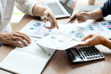 Teamwork concept, Business executives discussing document work at meeting in modern office lobby.