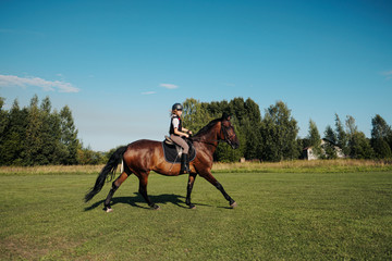 Girl teenager jockey trains on the field and at the hippodrome.