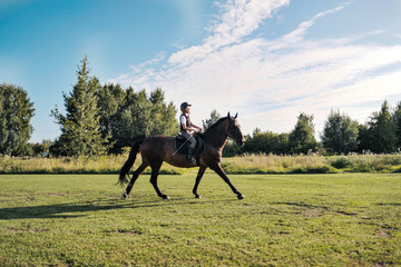 Girl teenager jockey trains on the field and at the hippodrome.