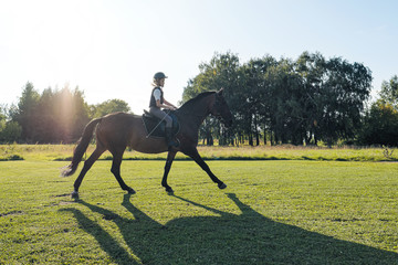 Girl teenager jockey trains on the field and at the hippodrome.