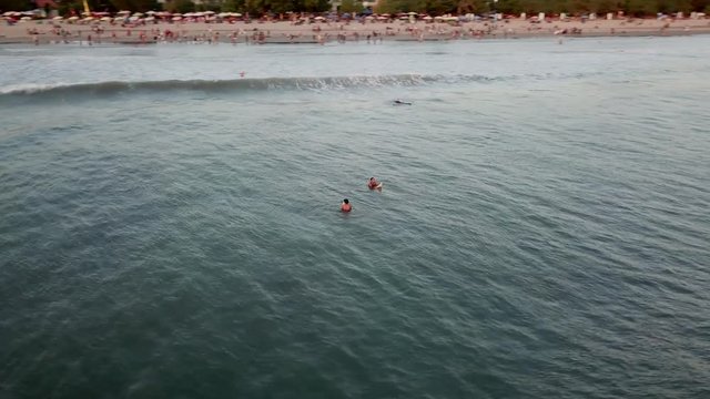 Legian Beach, Bali / Indonesia - July 2018: Surfers enjoying the waves off Legian Beach, Bali at sunset