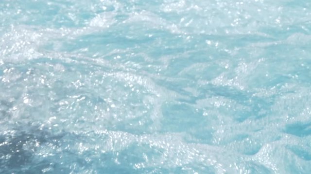 Jacuzzi water bubbles float about in waves.
