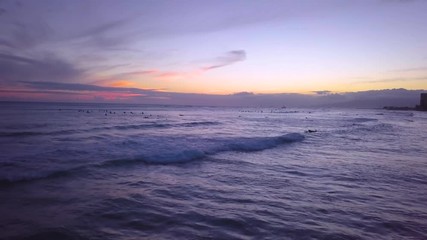 Surfers enjoy the sunset at Waikiki as they catch their final waves at dusk on the Hawaiian island of Oahu.
