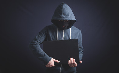 Hacker with laptop. Computer crime
