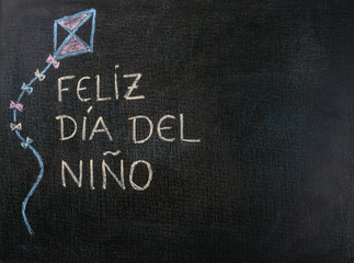 Blackboard written feliz dia del niño (spanish). Copy space.