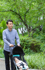 公園で散歩をする父親と赤ちゃん