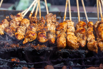 Thai street vendor sells grilled chicken meat at street food market in Thailand. Close up