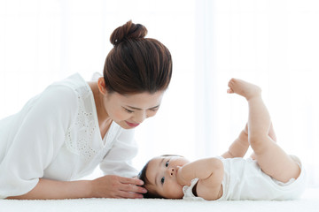寝転ぶ母親と赤ちゃん