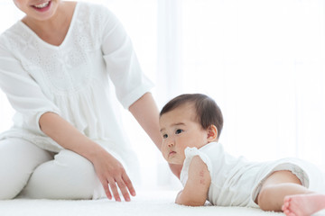 寝転ぶ赤ちゃんと母親