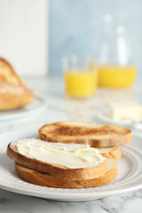 Tasty bread with butter served for breakfast on marble table. Space for text
