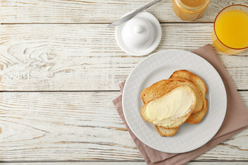 Tasty bread with butter served for breakfast on white wooden table, top view. Space for text - obrazy, fototapety, plakaty