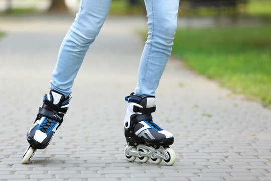 Woman roller skating on city street, closeup of legs