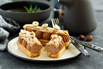 Homemade eclair with chocolate and nuts. Pastry.