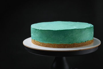Delicious homemade spirulina cheesecake on black background