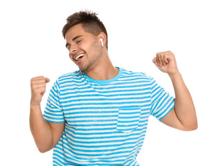Fototapeta premium Happy young man listening to music through wireless earphones on white background