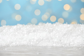 Heap of snow on wooden surface against blue background. Christmas season