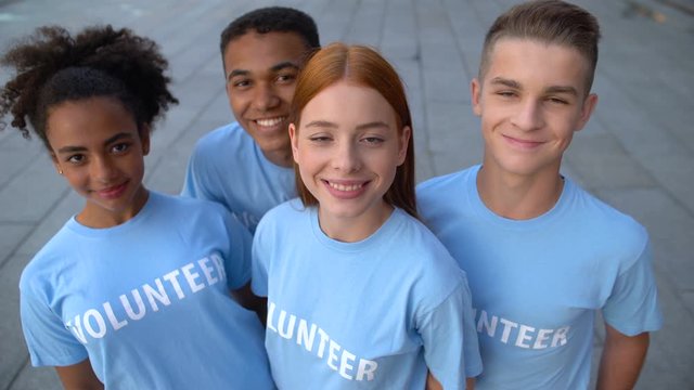 Multi-ethnic group of young volunteers looking camera, altruistic activity, help