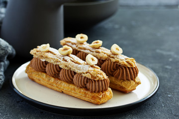 Homemade eclair with chocolate and nuts. Pastry.